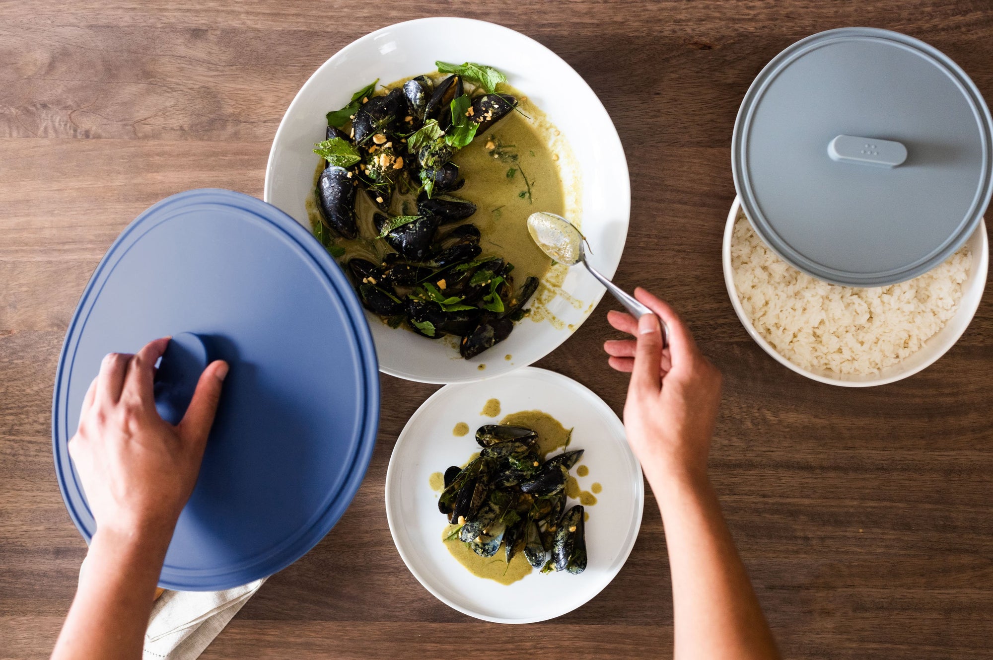 {{8-inch, 10-inch, 12-inch, 8-10-12-inch}} Lifting a 12 inch blue lid to serve a plate of french steamed mussels next to an 8 inch gray lid atop a bowl of rice.