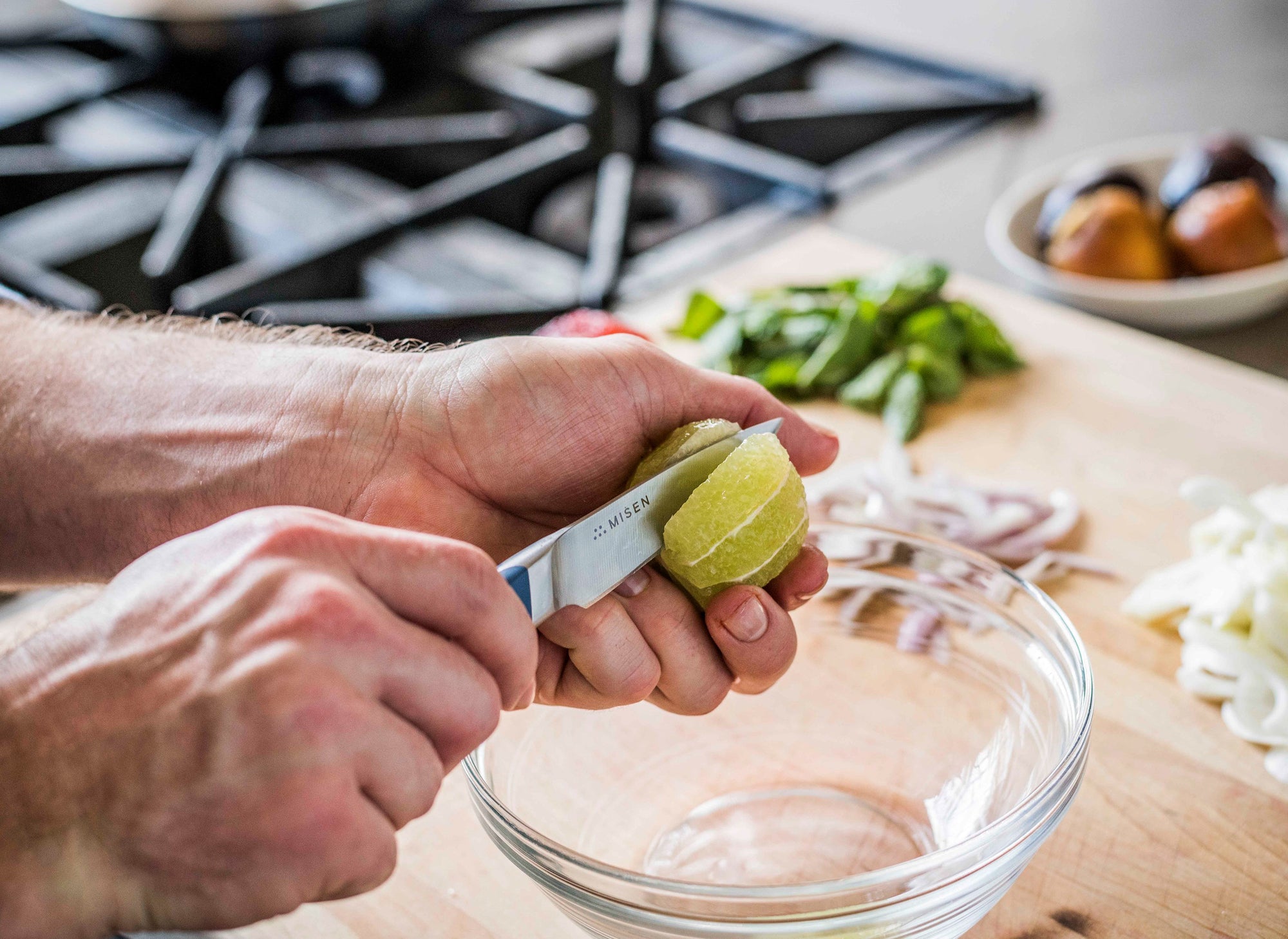 {{blue, black, gray}} The Misen Paring Knife can be used in a variety of ways, including cutting a lime into sections.