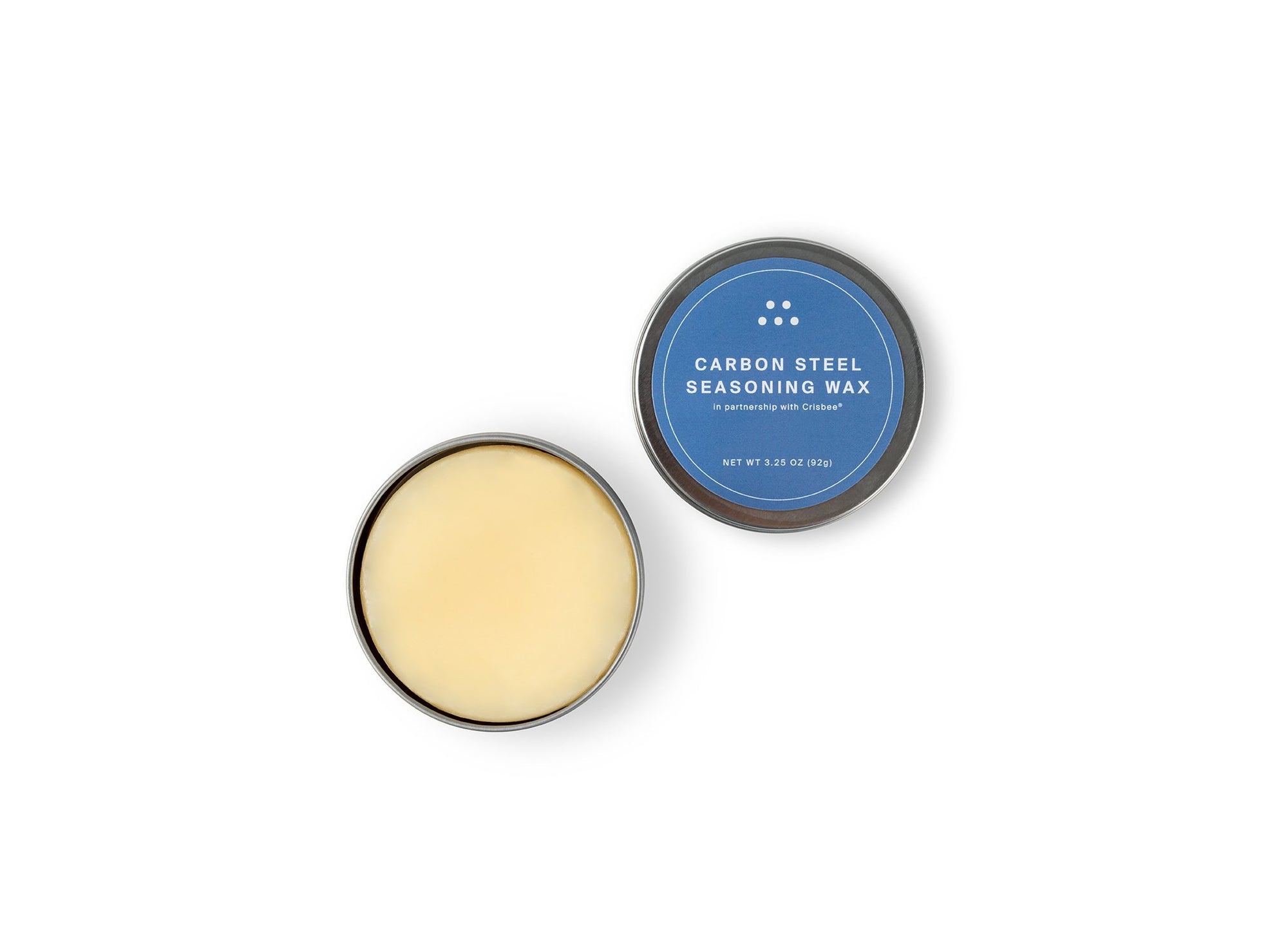 {{3-25-oz}} Misen Carbon Steel Seasoning Wax tin seen from above with blue lid removed to reveal pale yellow seasoning wax puck.