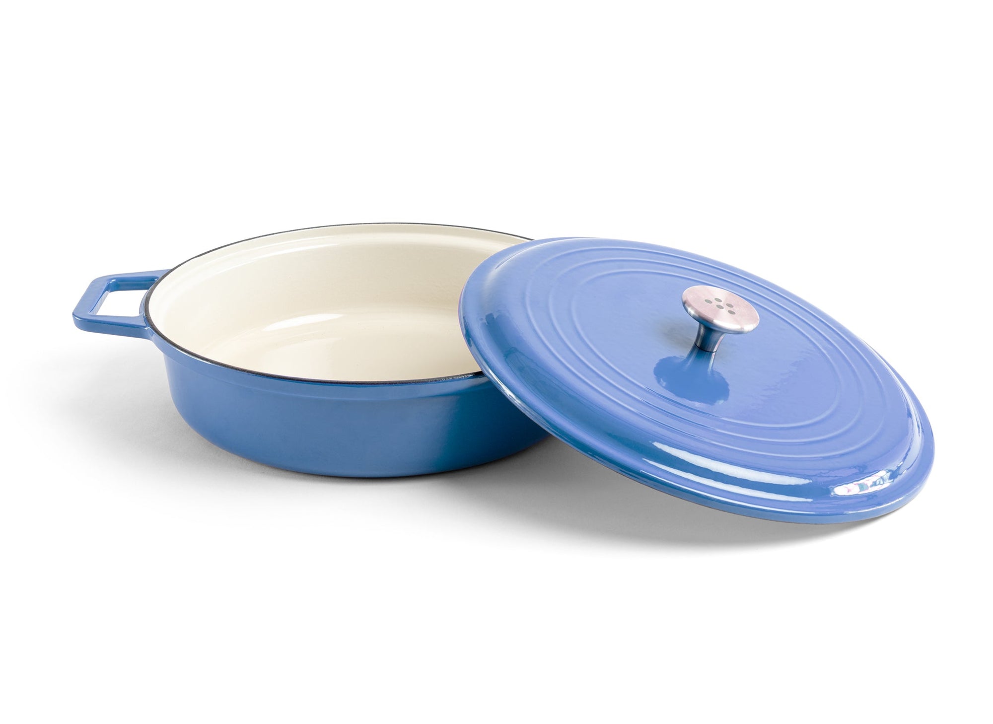 {{blue}} A blue Misen Enameled Cast Iron Braiser with knob-handle lid removed and resting against the pan’s side.