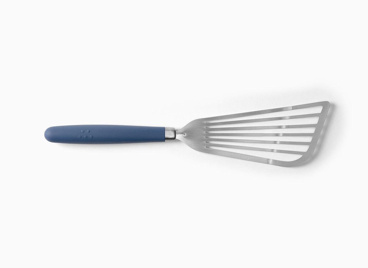 A Blue Misen Metal Fish Spatula on a white background. Shows a slotted and flared metal head attached to a silicone handle.