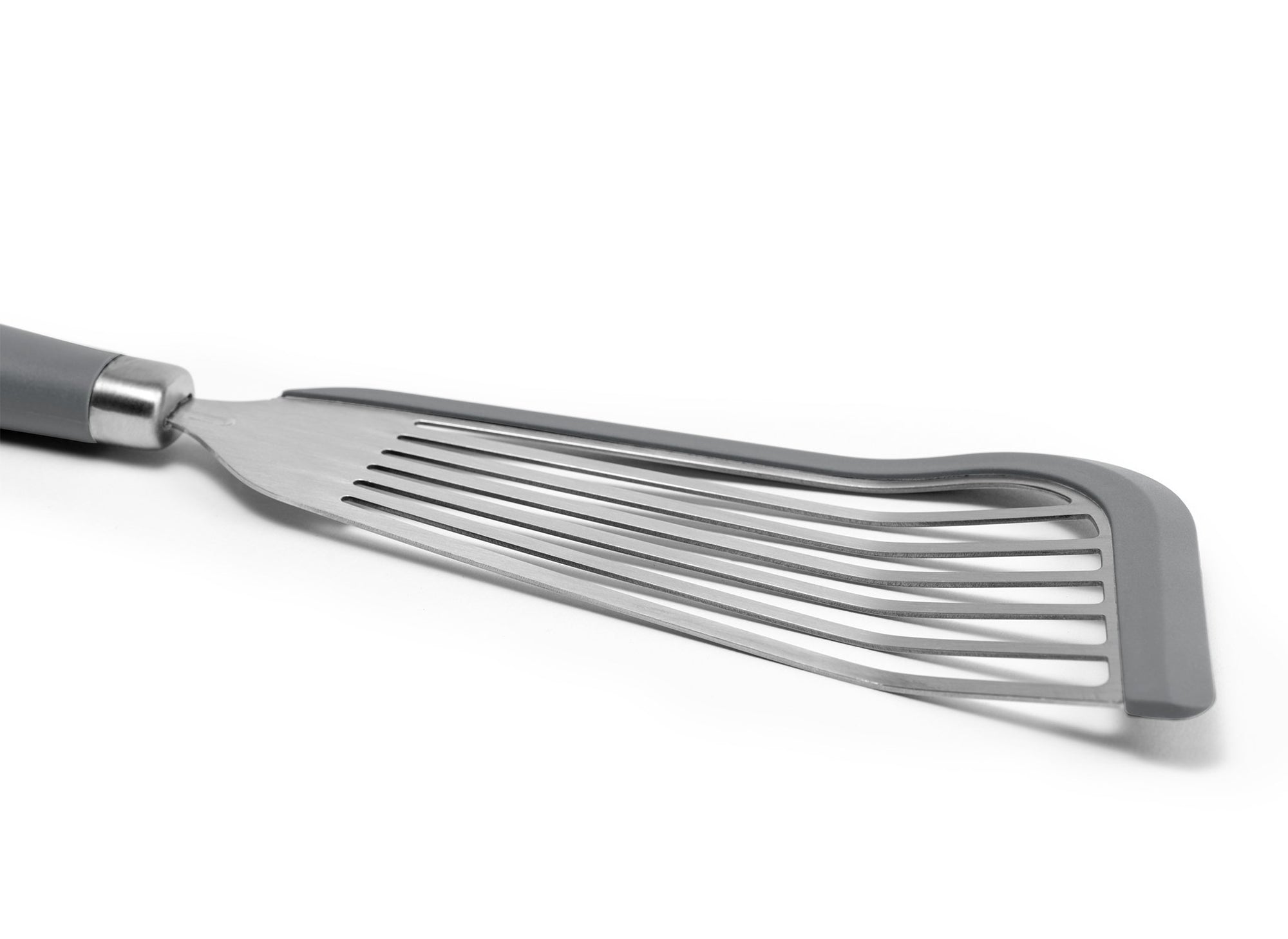 {{silicone-gray}} A close view of the Grey Misen Silicone Fish Spatula’s slotted metal head, showing a grey silicone lining along two edges.