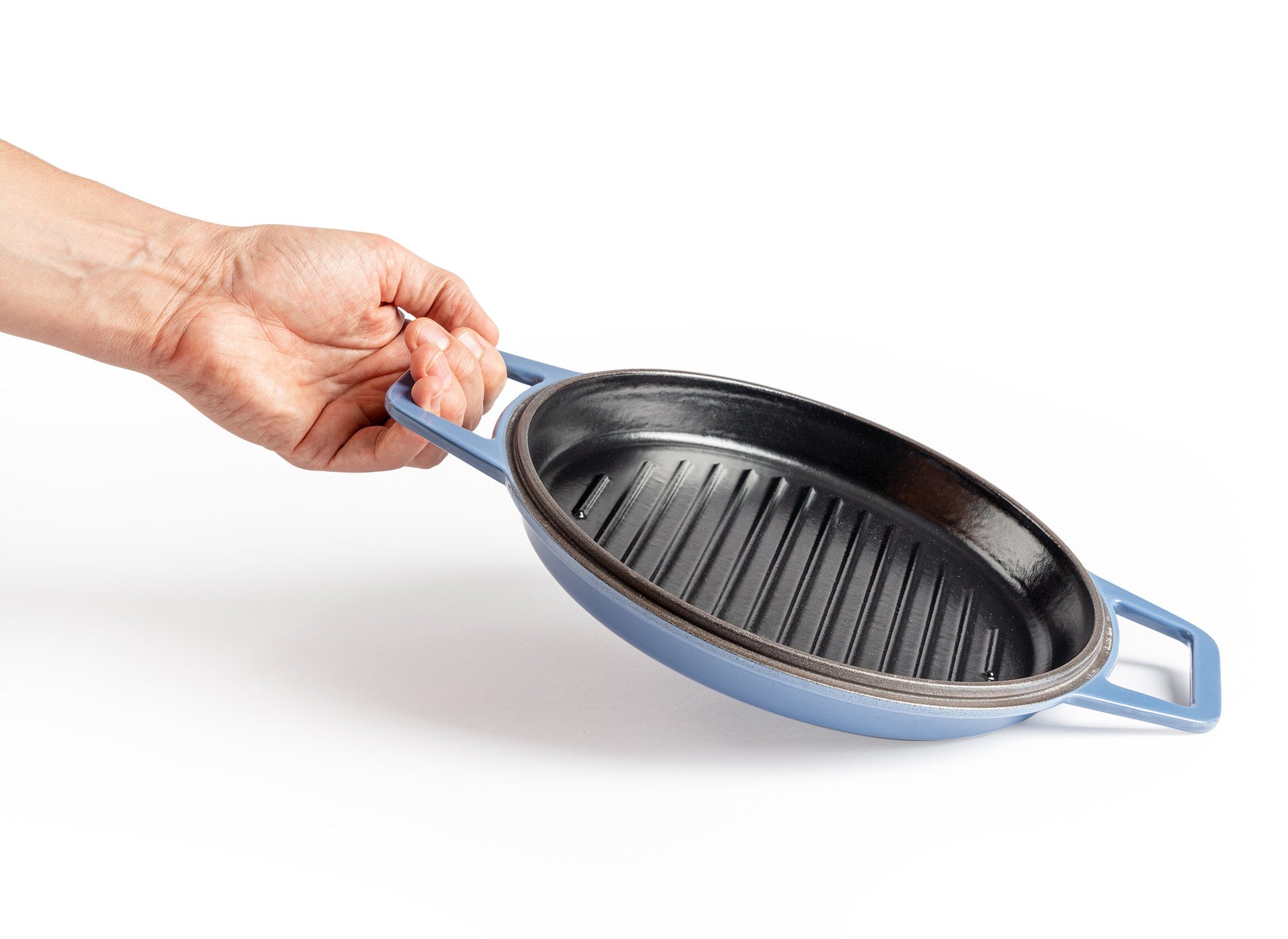 {{blue,7-qt-blue,9-qt-blue}} A hand lifts up a Blue Misen Enameled Cast Iron Grill pan by one of its two side handles.