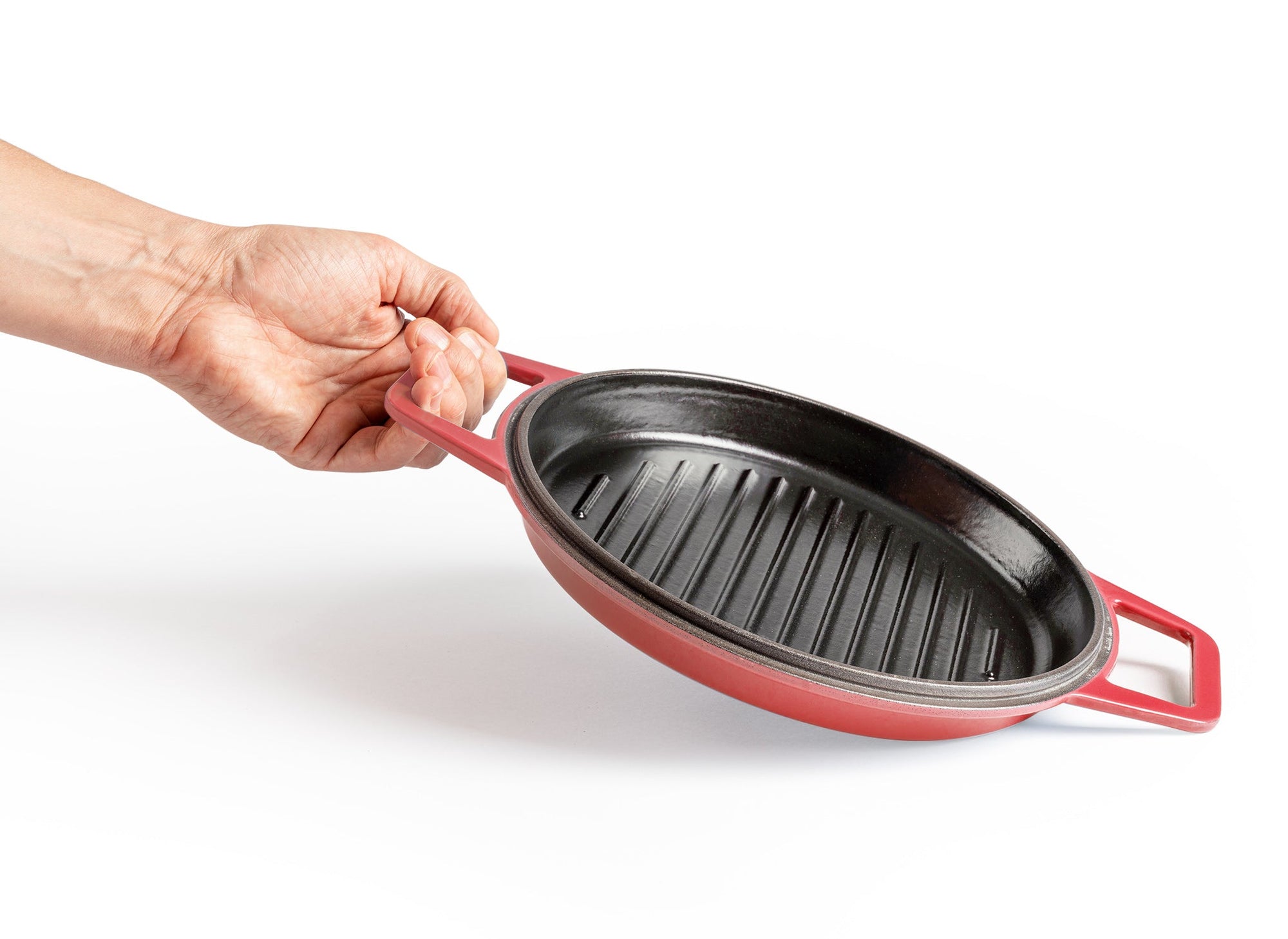{{red,7-qt-red,9-qt-red}} A hand lifts up a Red Misen Enameled Cast Iron Grill pan by one of its two side handles.