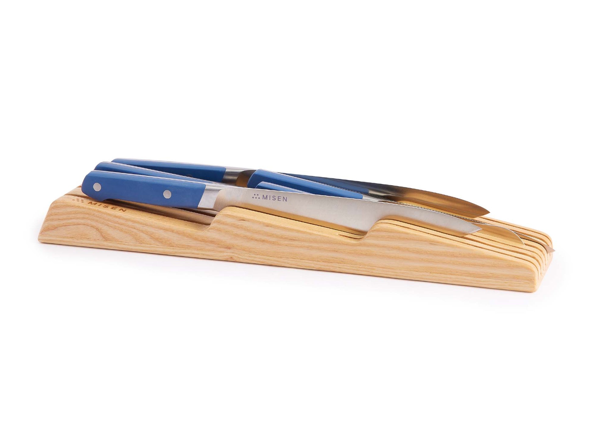 {{ash}} Misen In-Drawer Knife Storage in Ash, seen from a slight angle with Misen Chef’s, Serrated, and Paring Knives visible.