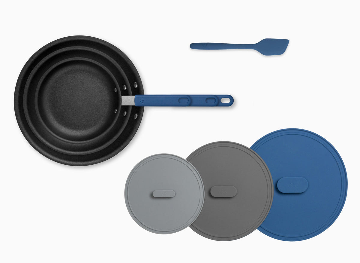 Three stacked Misen Nonstick Pans, three Universal Lids, and blue silicone Misen Spatula all viewed from above.