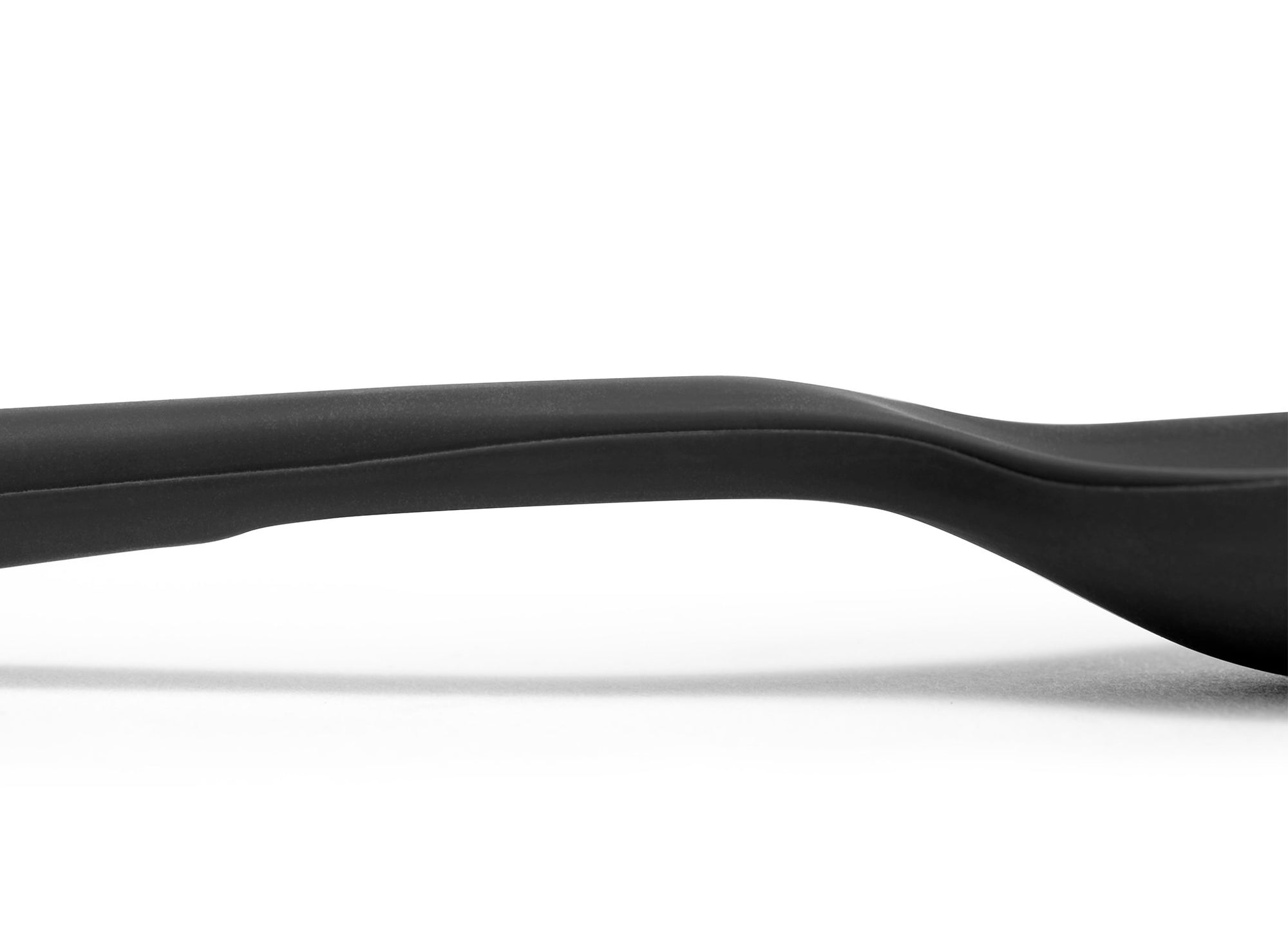 {{black}} A close view of the area where a Black Misen Mixing Spoon’s head meets its handle, with a flattened area visible on the bottom.