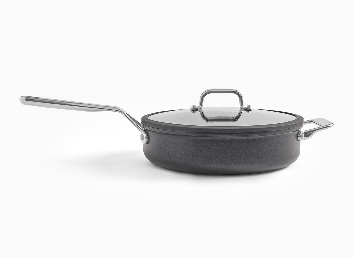 A sideways view of the Misen 3 QT Nonstick Sauté Pan, with lid on, on a white background.