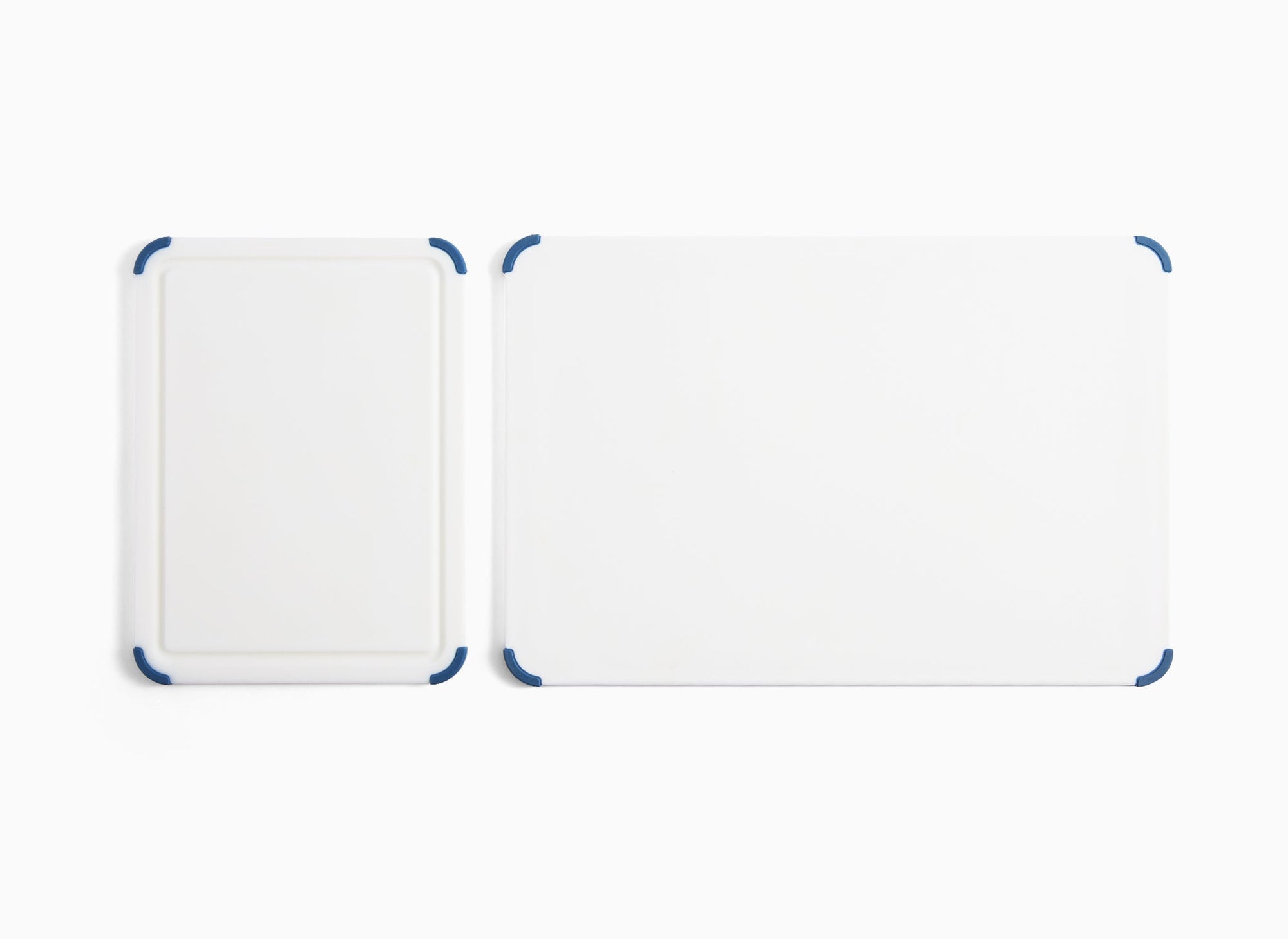 A 2-Piece Misen Plastic Cutting Board Set seen from overhead. Small board is face-up, while Large board is flipped to show its backside.