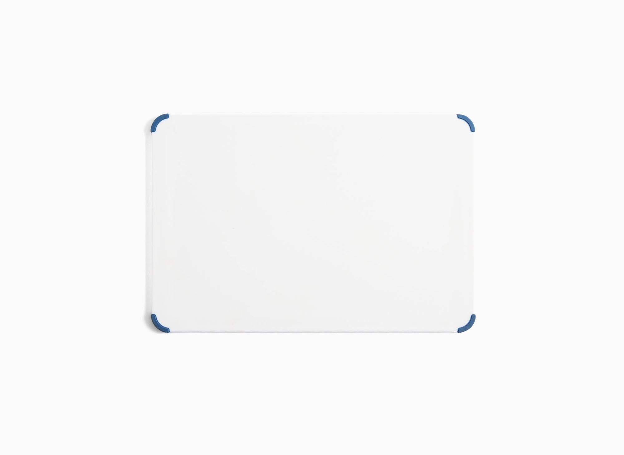 A view of the large Misen Plastic Cutting Board’s backside, with blue corner grips visible.