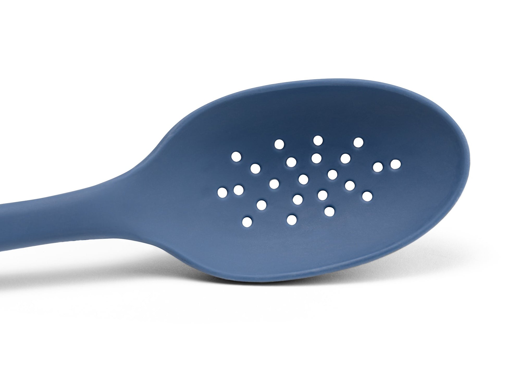 {{blue}} A close view from the front of a Blue Misen Slotted Spoon’s head with drainage holes visible on a white background.