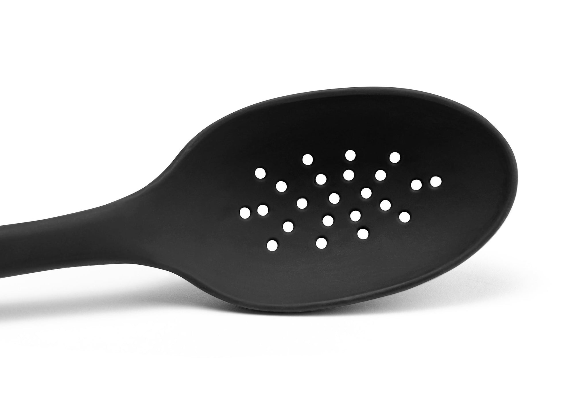 {{black}} A close view from the front of a Black Misen Slotted Spoon’s head with drainage holes visible on a white background.