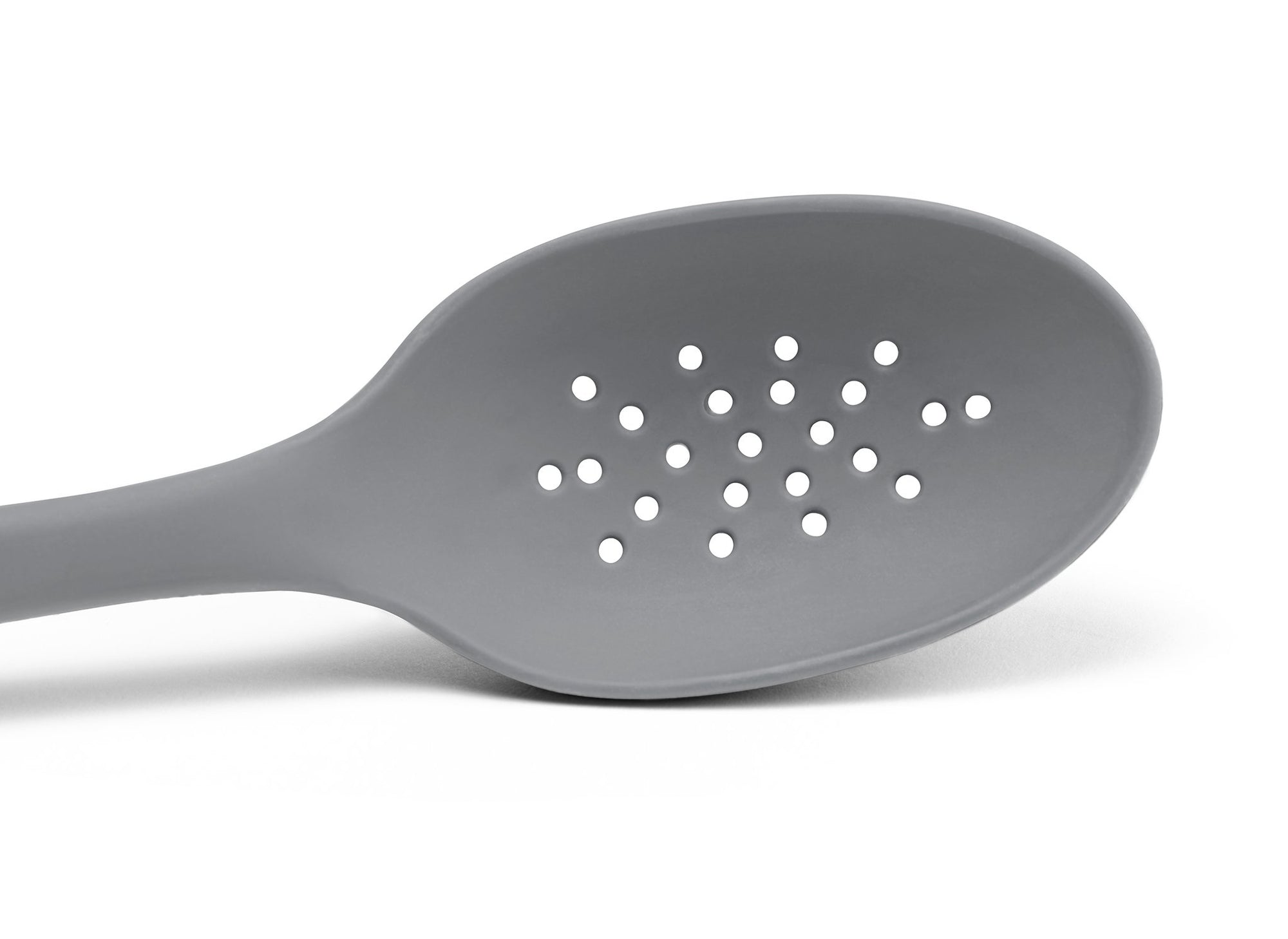 {{gray}} A close view from the front of a Grey Misen Slotted Spoon’s head with drainage holes visible on a white background.