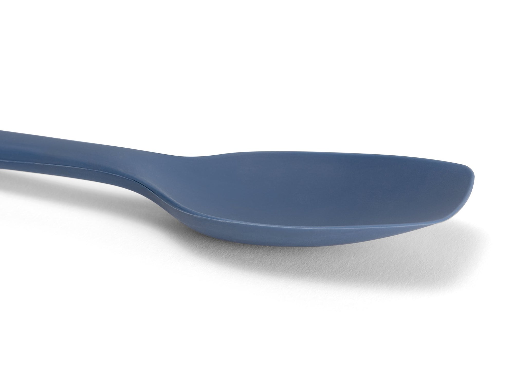 {{blue}} Close view of a Blue Misen Spoontula’s silicone head, deeply curved like a spoon with a spatula’s flexible rounded corners.