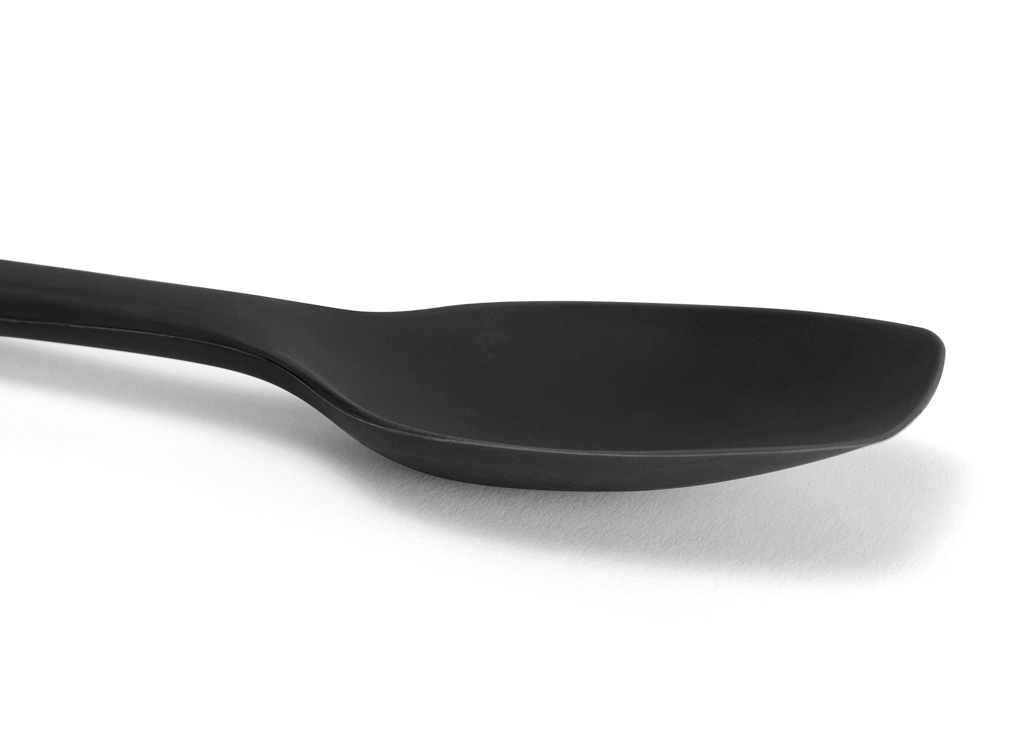 {{black}} Close view of a Black Misen Spoontula’s silicone head, deeply curved like a spoon with a spatula’s flexible rounded corners.