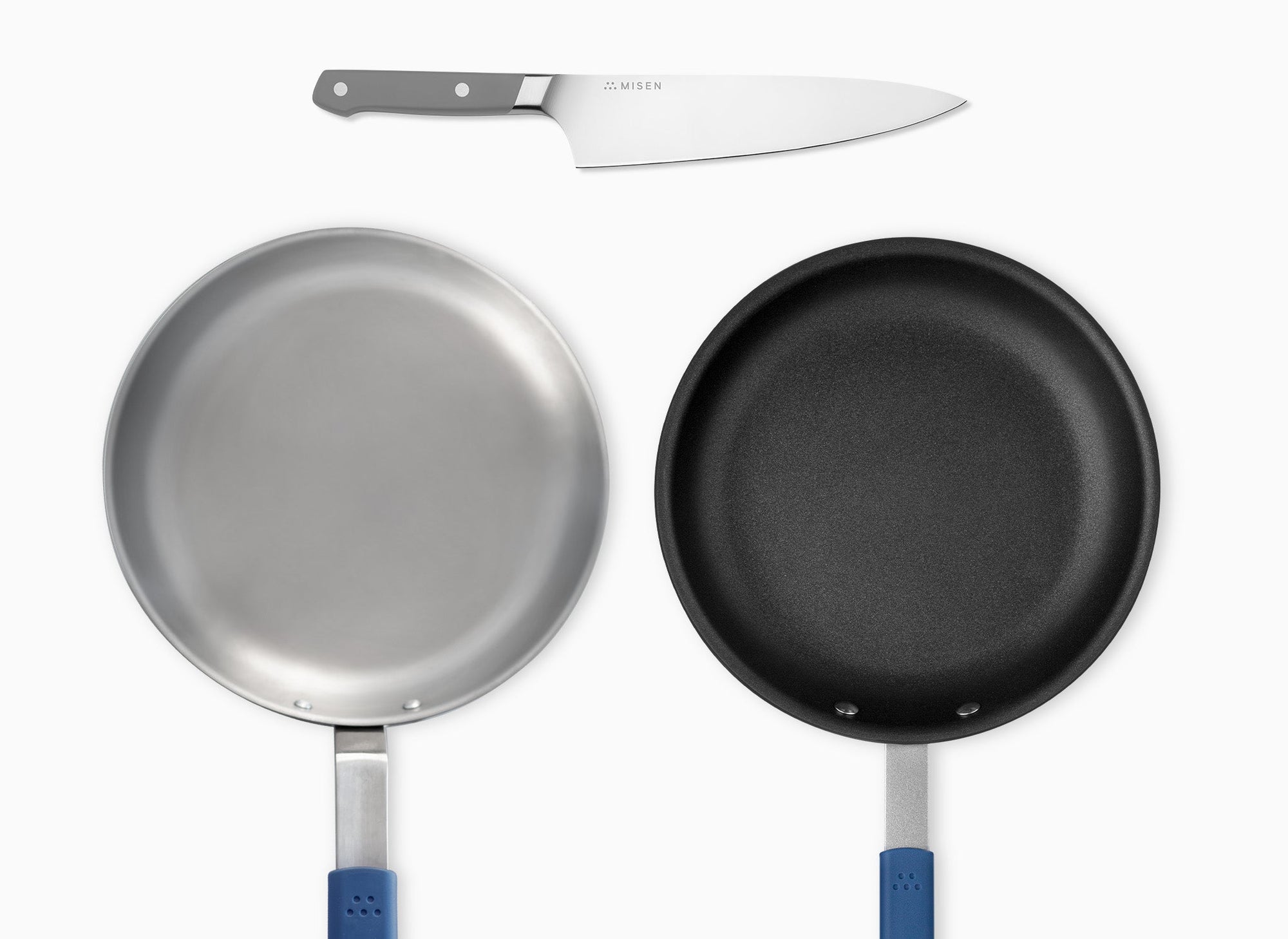A Grey Misen Chef’s Knife, Misen Nonstick Pan, and Misen Carbon Steel Pan seen from directly overhead.