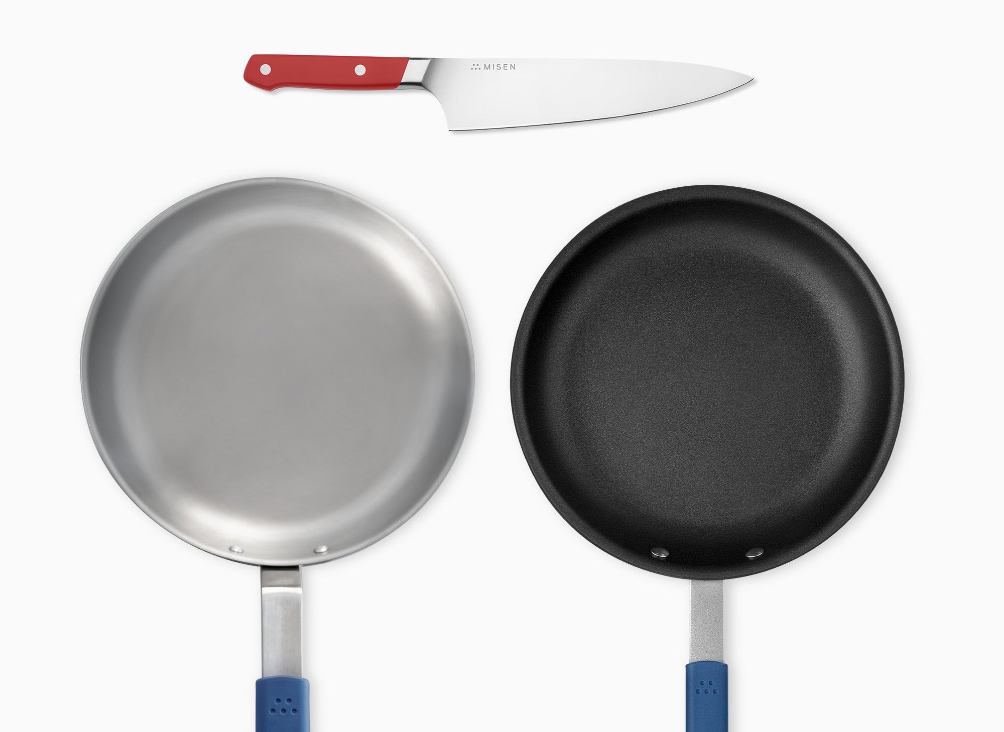 A Red Misen Chef’s Knife, Misen Nonstick Pan, and Misen Carbon Steel Pan seen from directly overhead.